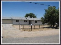 Hesperia home with mature trees and a fenced yard